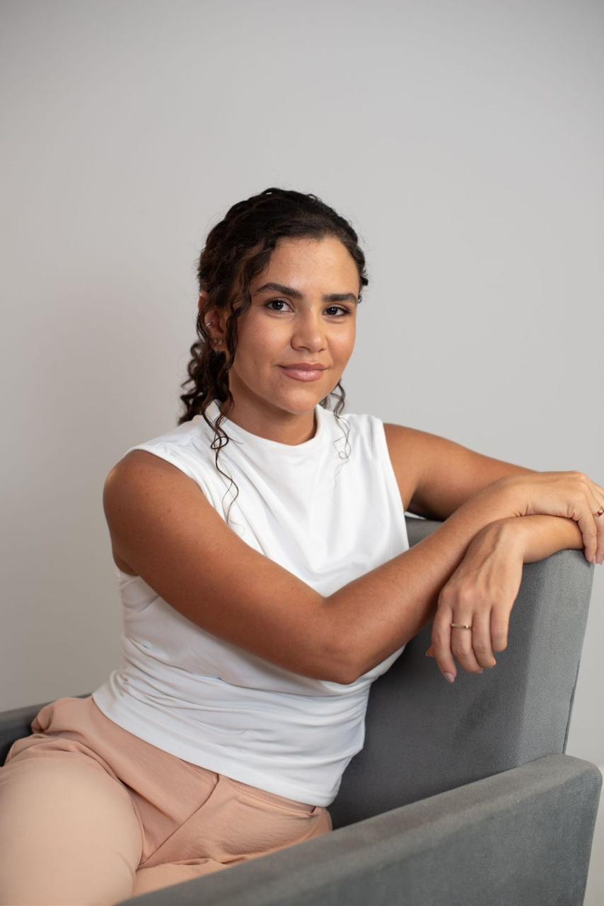 Alice de Oliveira Gomes apoiada em poltrona